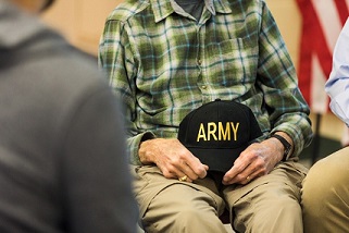 veteran holding an ARMY cap