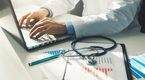 doctor working with medical statistics and financial reports in office, Image: iStock/ronstik
